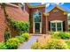 Attractive brick home showcasing front entrance with arched window and professionally landscaped walkway at 10418 Pullengreen Dr, Charlotte, NC 28277