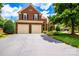Charming brick home featuring a two-car garage, lush landscaping, and a welcoming driveway at 10418 Pullengreen Dr, Charlotte, NC 28277