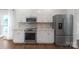 Modern kitchen displaying white cabinets, stainless steel appliances, and tile backsplash at 10418 Pullengreen Dr, Charlotte, NC 28277