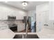 Modern kitchen with stainless steel appliances, white cabinets, quartz countertops, and tile backsplash at 10418 Pullengreen Dr, Charlotte, NC 28277