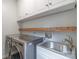 Functional laundry room with stainless steel washer, dryer, sink and upper cabinets for storage at 10418 Pullengreen Dr, Charlotte, NC 28277