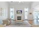 Bright living room with high ceilings, a fireplace, hardwood floors, and large windows at 10418 Pullengreen Dr, Charlotte, NC 28277