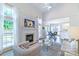 Sunlit living room showcasing fireplace, hardwood floors, and an open layout to the dining area at 10418 Pullengreen Dr, Charlotte, NC 28277