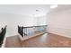 Bright open loft area features hardwood floors and a decorative pendant light at 10418 Pullengreen Dr, Charlotte, NC 28277