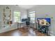 Spacious home office features a desk setup, shelving and hardwood flooring at 10418 Pullengreen Dr, Charlotte, NC 28277