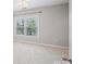 Bedroom with neutral carpet and walls features a window with trees visible outside at 11335 Wescott Hill Dr, Huntersville, NC 28078