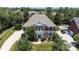 Stately brick home featuring a well-manicured lawn, mature trees, and an inviting front porch with columns at 11335 Wescott Hill Dr, Huntersville, NC 28078