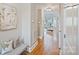 Hallway with wood floors, a cushioned bench, and a view into a bright living room at 11335 Wescott Hill Dr, Huntersville, NC 28078