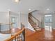 Upstairs hallway with wood floors, staircase, and decorative railing overlooking foyer at 11335 Wescott Hill Dr, Huntersville, NC 28078