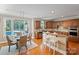 Eat-in kitchen showcasing wood cabinets, stainless appliances, breakfast bar, and views of the swimming pool at 11335 Wescott Hill Dr, Huntersville, NC 28078