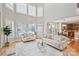 Sun-filled living room featuring large windows, neutral decor, and an open floor plan leading to the kitchen at 11335 Wescott Hill Dr, Huntersville, NC 28078