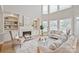 Bright living room with high ceilings, fireplace, built-in bookshelves, and large windows at 11335 Wescott Hill Dr, Huntersville, NC 28078