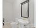 Elegant powder room with pedestal sink, designer mirror and tiled floors at 11335 Wescott Hill Dr, Huntersville, NC 28078