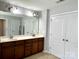 Bathroom featuring a dual sink vanity with dark wood cabinets and a large mirror at 11511 Wilson Mill Ln, Pineville, NC 28134
