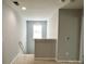 A simple hallway with gray walls, carpet, and a window at the end at 11511 Wilson Mill Ln, Pineville, NC 28134