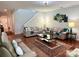 Inviting living room with hardwood floors, sofas, decorative rug, modern chandelier, and staircase at 11511 Wilson Mill Ln, Pineville, NC 28134