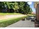 Spacious backyard with a fire pit, paved patio, retaining wall, green grass, and mature trees at 121 Canterbury Xing, Fort Mill, SC 29708