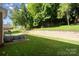 Picturesque backyard with lush greenery, a retaining wall, a patio, and a swing set for outdoor fun at 121 Canterbury Xing, Fort Mill, SC 29708