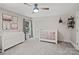 Bright Bedroom with a white crib, modern changing table, stylish ceiling fan, and unique wall accents at 121 Canterbury Xing, Fort Mill, SC 29708