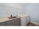 Functional laundry room with modern washer and dryer, gray countertops, and overhead storage at 121 Canterbury Xing, Fort Mill, SC 29708