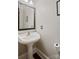 Powder room featuring pedestal sink, decorative mirror, and hardwood floors at 121 Canterbury Xing, Fort Mill, SC 29708