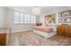 A charming bedroom with a large window, stylish rug, and artistic decorations at 1300 Reece Rd # 206, Charlotte, NC 28209