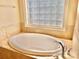 This bathroom has a large tub with tile surround and a block window at 1302 Devonmere Pl, Salisbury, NC 28144
