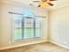 Neutral bedroom showcasing a large window, ceiling fan, blinds, and carpeted floor at 1302 Devonmere Pl, Salisbury, NC 28144