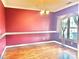 Dining room featuring vibrant two-tone walls, hardwood floors, crown molding, and natural light from large window at 1302 Devonmere Pl, Salisbury, NC 28144