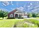 Charming red brick home with stone accents, covered porch, manicured lawn, and attached two-car garage at 1302 Devonmere Pl, Salisbury, NC 28144