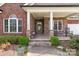 Inviting front porch with stone columns and accents, featuring a seating area, ideal for relaxing at 1302 Devonmere Pl, Salisbury, NC 28144