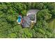 Aerial view of a secluded home surrounded by lush trees, pool, and multi-car garage at 1317 Longleaf Ct, Matthews, NC 28104