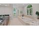 Luxury bathroom with a soaking tub, natural light, and tiled floors at 1317 Longleaf Ct, Matthews, NC 28104