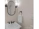 Traditional bathroom featuring a white sink, oval mirror and decorative lighting at 1317 Longleaf Ct, Matthews, NC 28104