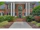 Grand front entrance with classic columns, arched windows, and a well-manicured garden at 1317 Longleaf Ct, Matthews, NC 28104
