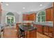 Gourmet kitchen with cherry cabinets, granite countertops, and an island with seating at 1317 Longleaf Ct, Matthews, NC 28104