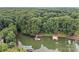 Aerial view of lakefront property showing the lush surrounding trees, waterfront and private docks at 138 Ardmore Pl, Mooresville, NC 28117