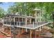 Expansive elevated deck featuring a screened porch and spiral staircase, surrounded by lush greenery and mature trees at 138 Ardmore Pl, Mooresville, NC 28117