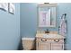 Cozy powder room featuring a classic vanity with sink, framed mirror, and soft blue walls at 138 Ardmore Pl, Mooresville, NC 28117