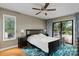 Bright bedroom featuring hardwood floors, a ceiling fan, and sliding glass doors to the outside deck at 138 Ardmore Pl, Mooresville, NC 28117