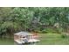 Waterfront home featuring a covered dock with a boat lift, lush landscaping, and lake views at 138 Ardmore Pl, Mooresville, NC 28117