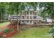 Back exterior view with a large deck, patios, spiral staircases, lake view and manicured lawn at 138 Ardmore Pl, Mooresville, NC 28117