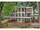 Back exterior showing the large deck, patios, spiral staircases, lake views and landscaped yard at 138 Ardmore Pl, Mooresville, NC 28117