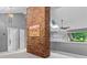Bright living room featuring an exposed brick column and a skylight, with a view to the hall and backyard at 138 Ardmore Pl, Mooresville, NC 28117