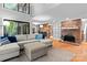 Open-concept living room featuring a brick fireplace, hardwood floors, comfortable seating, and a view of the kitchen at 138 Ardmore Pl, Mooresville, NC 28117