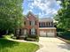 Charming two-story brick home with a two-car garage, manicured lawn, and beautiful landscaping at 14746 Greenpoint Ln, Huntersville, NC 28078