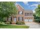 Charming two-story brick home featuring a well-manicured front yard and a three-car garage at 14746 Greenpoint Ln, Huntersville, NC 28078