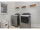 Functional laundry room with modern washer and dryer, shelving and humorous wall decor at 14746 Greenpoint Ln, Huntersville, NC 28078