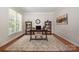 Bright office space with large window, hardwood floors, stylish rug, and two bookcases at 14746 Greenpoint Ln, Huntersville, NC 28078