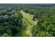 Aerial shot of a golf course winding through lush trees and featuring a small pond at 1543 Withers Dr, Denver, NC 28037